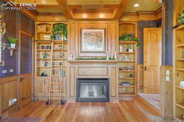 unfurnished living room featuring light wood-type flooring, beamed ceiling, coffered ceiling, and built in shelves