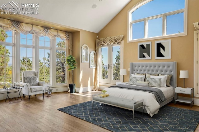 bedroom with french doors, hardwood / wood-style floors, and high vaulted ceiling