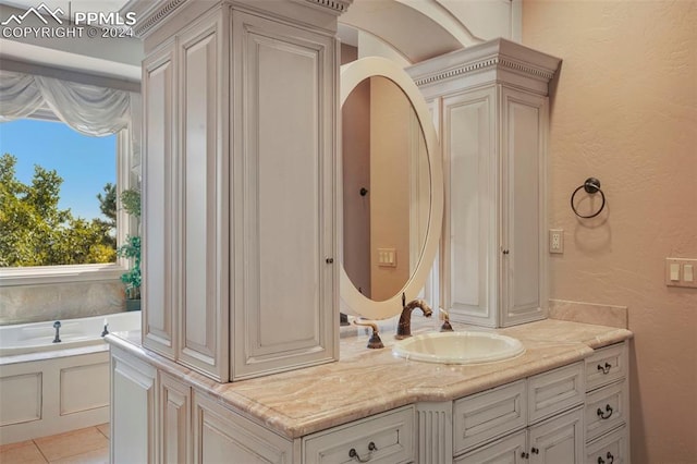 bathroom with a tub to relax in, tile patterned flooring, and vanity