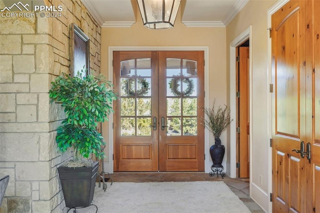 entryway with ornamental molding and french doors