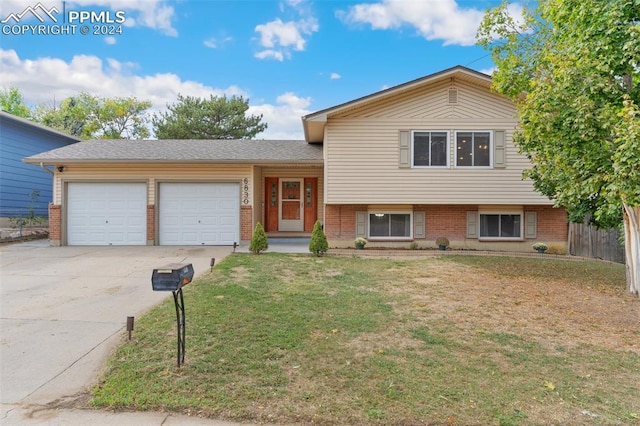 tri-level home with a garage and a front yard