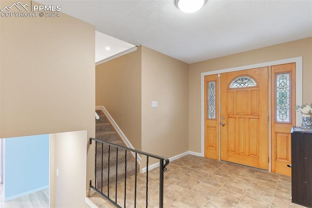 entrance foyer with stairs and baseboards