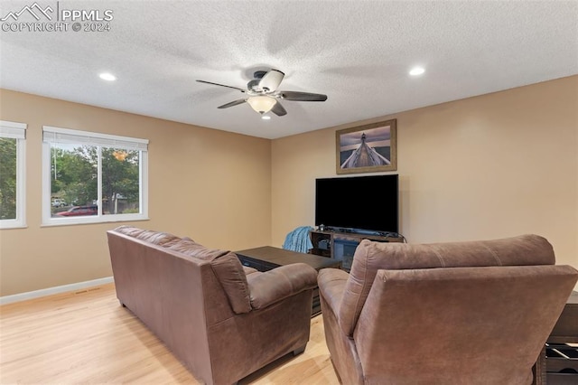 living room with a textured ceiling, light wood-style floors, a ceiling fan, and recessed lighting