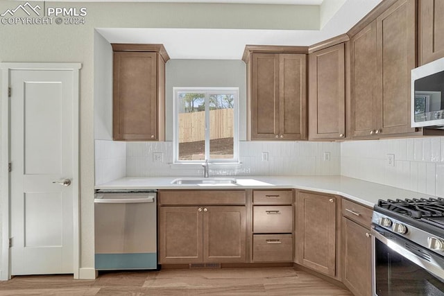 kitchen featuring stainless steel appliances, a sink, and backsplash