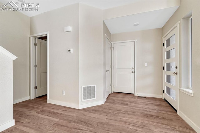 interior space featuring light wood-style floors, visible vents, and baseboards