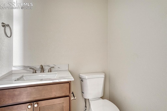 half bathroom with vanity and toilet