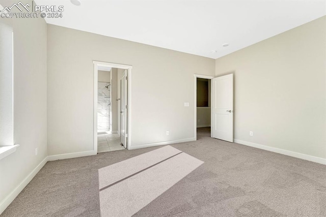 unfurnished bedroom featuring carpet, connected bathroom, and baseboards