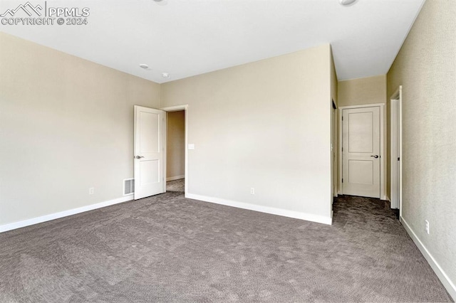 unfurnished bedroom featuring carpet, visible vents, and baseboards