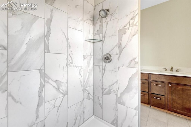 full bathroom featuring tiled shower and vanity