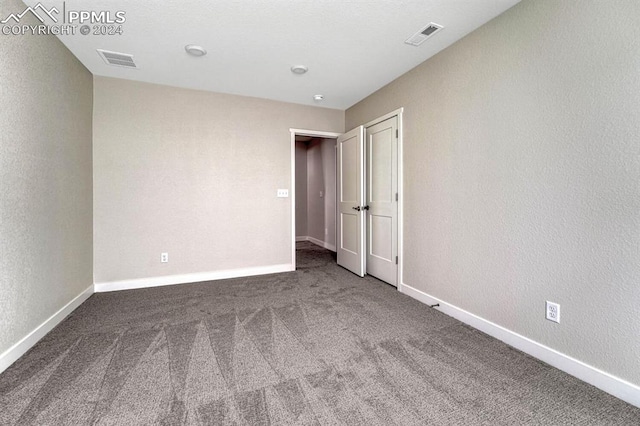 spare room with carpet floors, visible vents, and baseboards