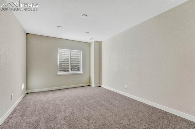 unfurnished room with carpet floors and baseboards