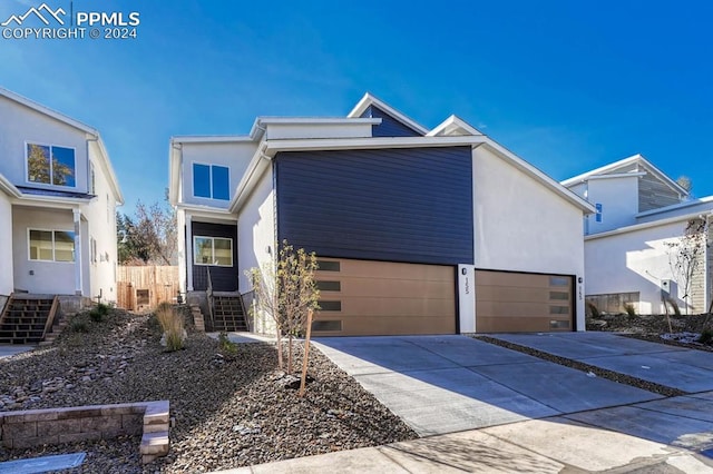 view of front of property featuring a garage, concrete driveway, and stucco siding