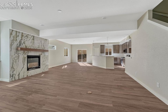 unfurnished living room with dark wood-style flooring, baseboards, and a premium fireplace