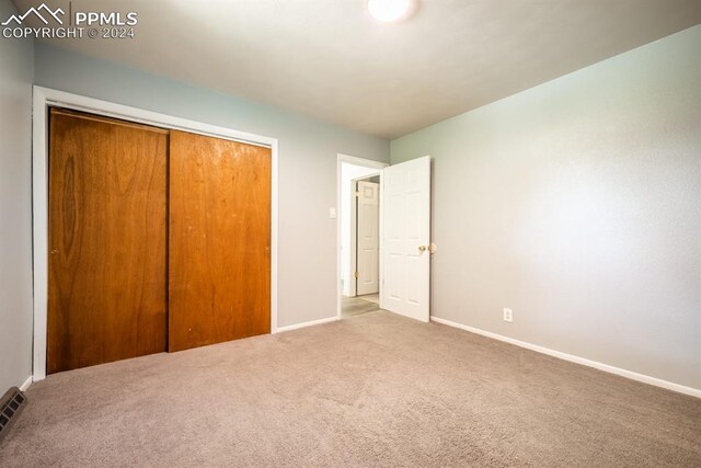 unfurnished bedroom featuring carpet floors and a closet