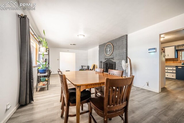 dining space featuring hardwood / wood-style flooring and a fireplace