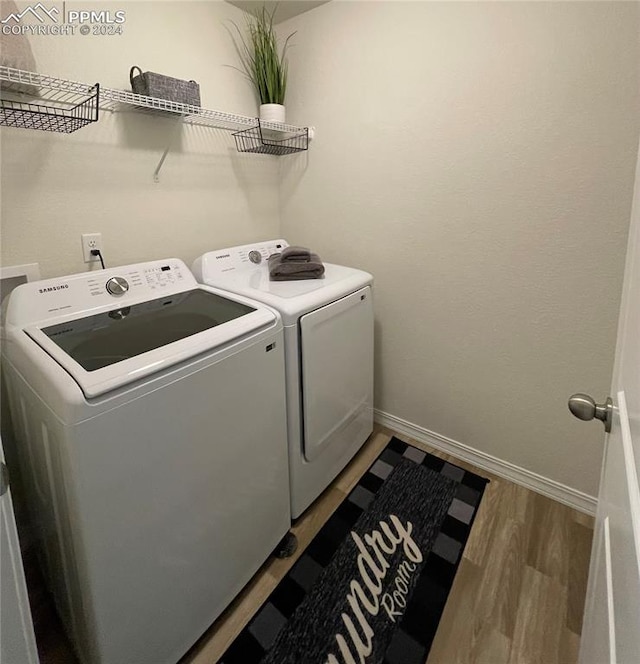 laundry room with light hardwood / wood-style flooring and washing machine and dryer