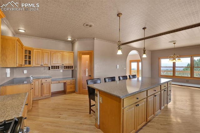 kitchen with a kitchen island, a breakfast bar area, pendant lighting, light hardwood / wood-style floors, and a baseboard heating unit