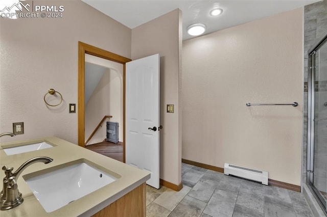 bathroom with vanity, a shower with shower door, and a baseboard radiator