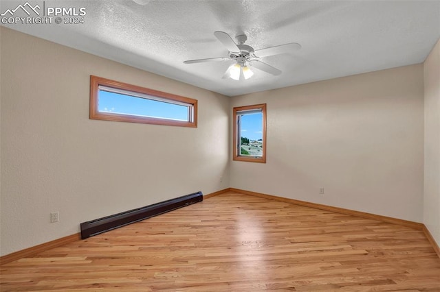 spare room with a textured ceiling, a baseboard radiator, ceiling fan, and light hardwood / wood-style floors