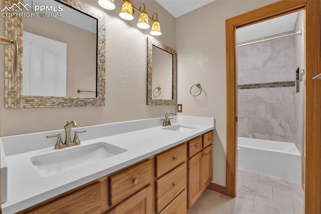 bathroom featuring tiled shower / bath combo, vanity, and tile patterned flooring