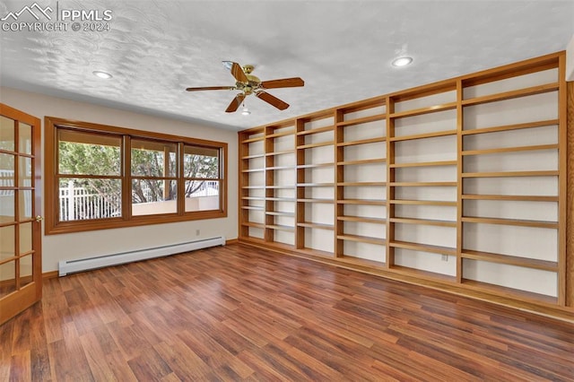 spare room with a textured ceiling, baseboard heating, hardwood / wood-style floors, and ceiling fan