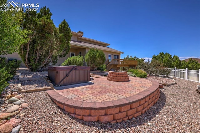 view of patio / terrace with a hot tub and a deck