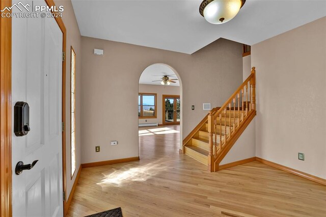 entrance foyer featuring crown molding, a baseboard radiator, and light hardwood / wood-style floors