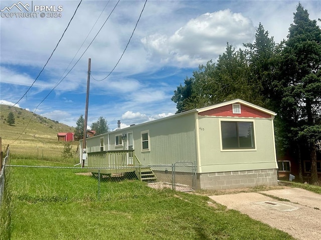 view of home's exterior with a yard and a wooden deck