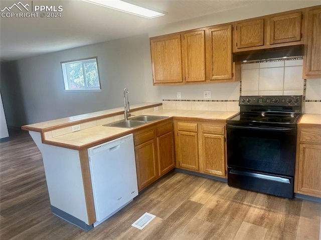 kitchen with dishwasher, kitchen peninsula, electric range, and tile countertops