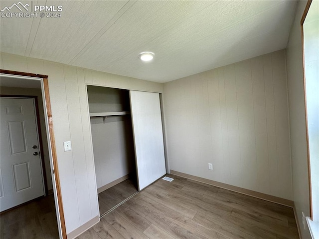 unfurnished bedroom featuring light hardwood / wood-style flooring and a closet