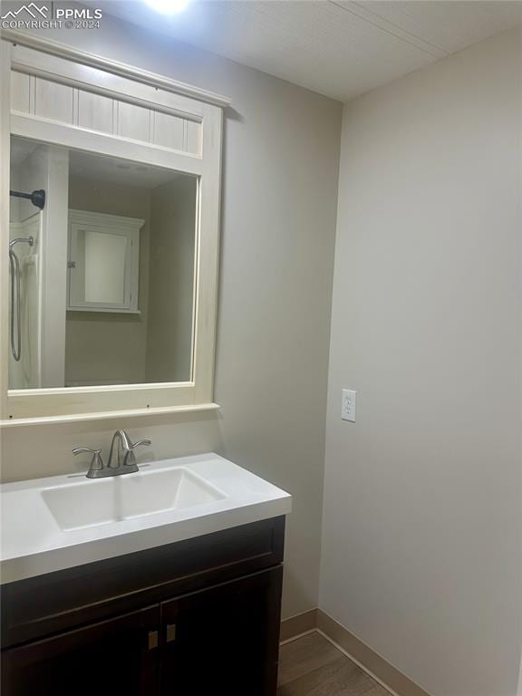 bathroom featuring a shower and vanity