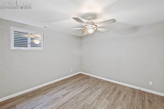 empty room featuring hardwood / wood-style floors, ceiling fan, and a textured ceiling