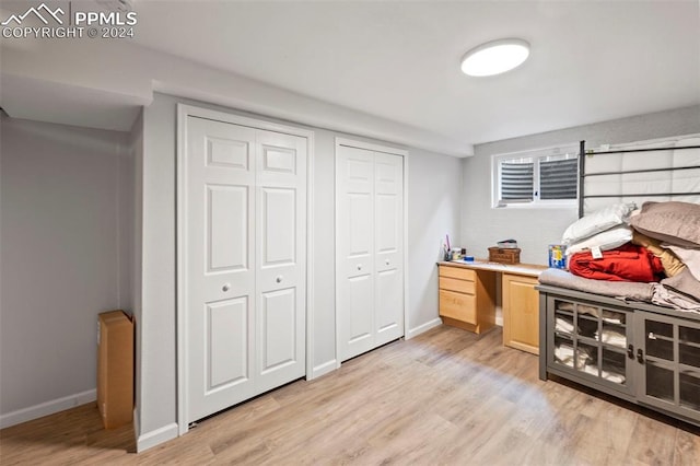 bedroom featuring two closets and light hardwood / wood-style flooring