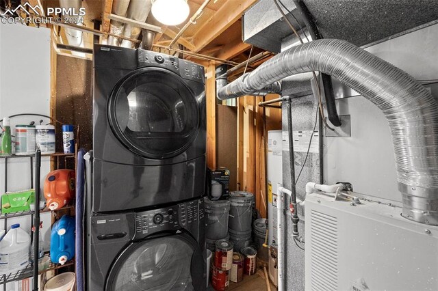 utility room with stacked washer and dryer