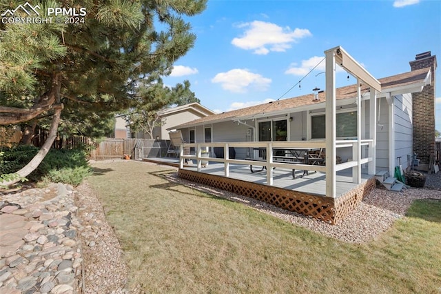 back of house with a wooden deck and a lawn