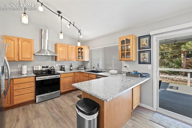 kitchen with decorative light fixtures, appliances with stainless steel finishes, kitchen peninsula, light stone counters, and wall chimney range hood