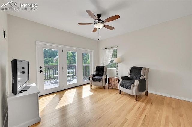 living area with ceiling fan and light hardwood / wood-style flooring