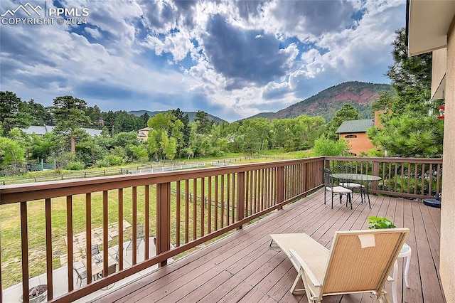 deck featuring a mountain view and a yard