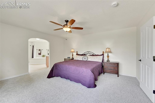 bedroom featuring ceiling fan, light carpet, and ensuite bathroom