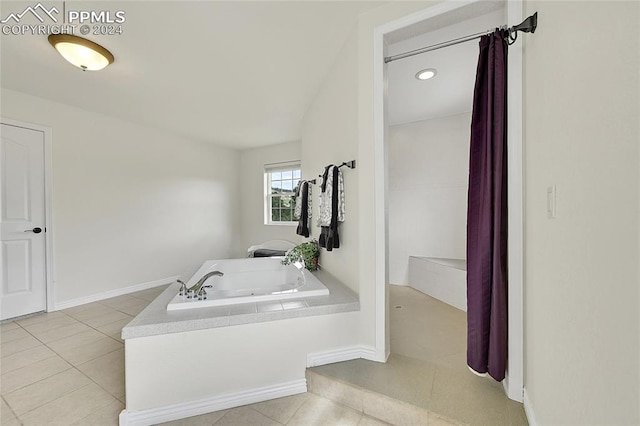 bathroom featuring tile patterned flooring and tiled bath