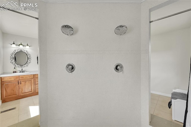 bathroom with vanity, tile patterned floors, and a tile shower