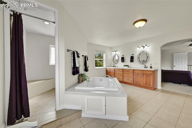 bathroom featuring tile patterned flooring, a tub, ceiling fan, and vanity