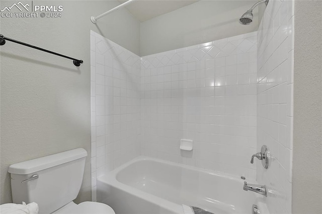 bathroom featuring tiled shower / bath and toilet