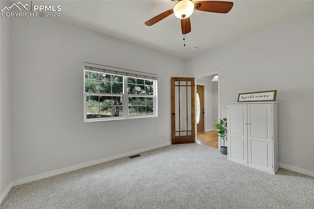 unfurnished bedroom featuring light colored carpet and ceiling fan