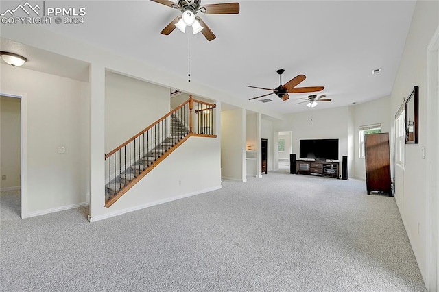 unfurnished living room featuring ceiling fan and light carpet