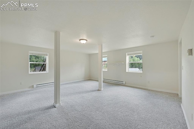 spare room with a textured ceiling, a baseboard radiator, and light colored carpet