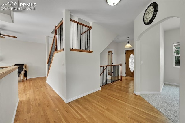 staircase with ceiling fan and hardwood / wood-style flooring