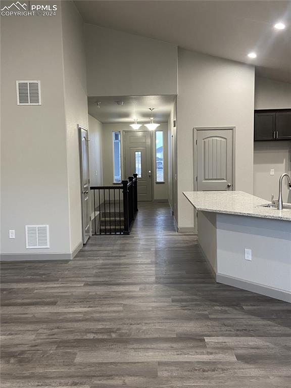 hall featuring dark hardwood / wood-style floors, sink, and vaulted ceiling