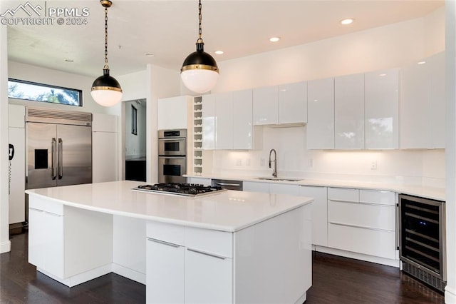 kitchen featuring white cabinetry, a kitchen island, sink, and decorative light fixtures