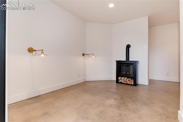 unfurnished living room featuring a wood stove